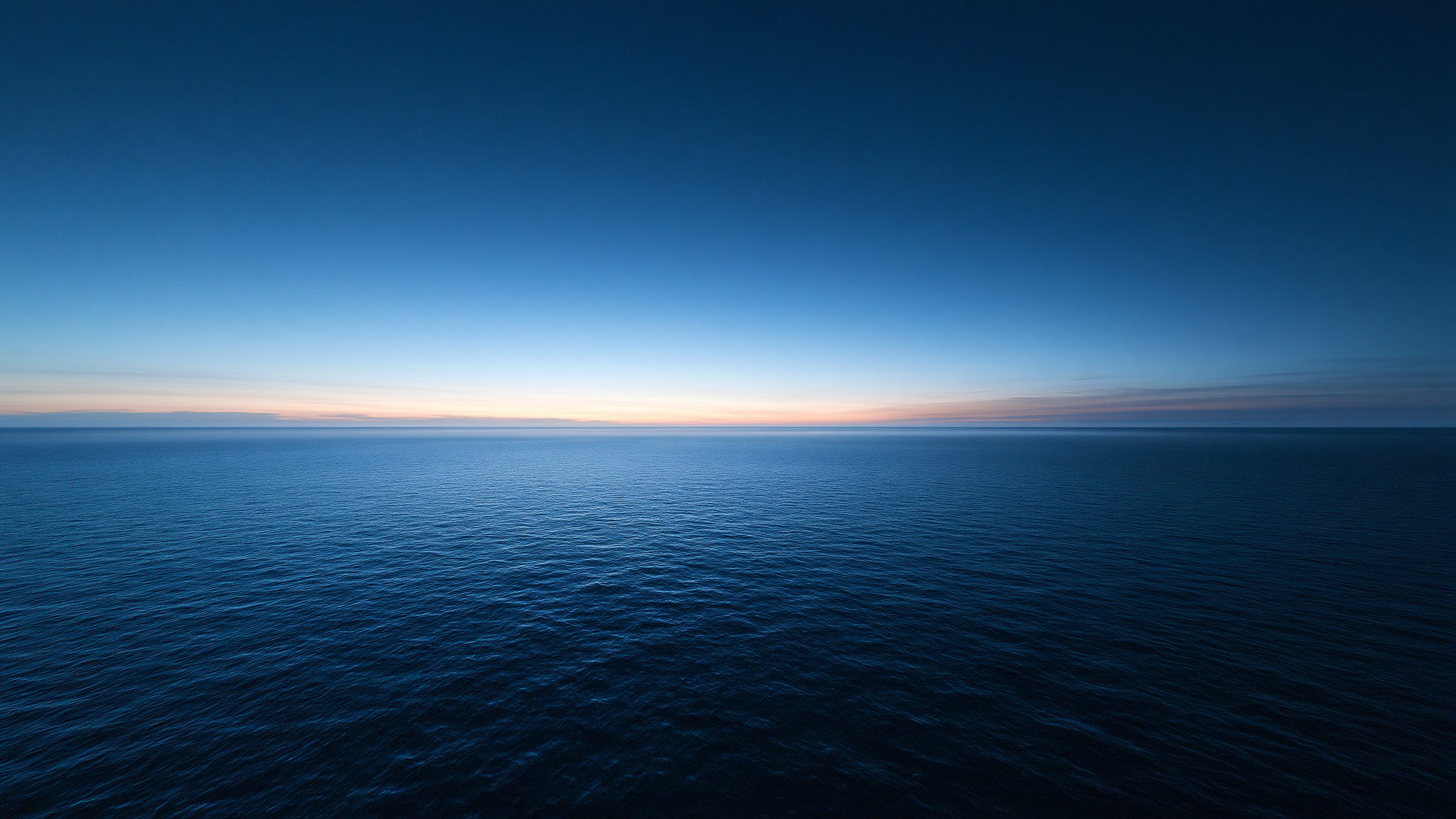 Dawn light breaking low over still water.